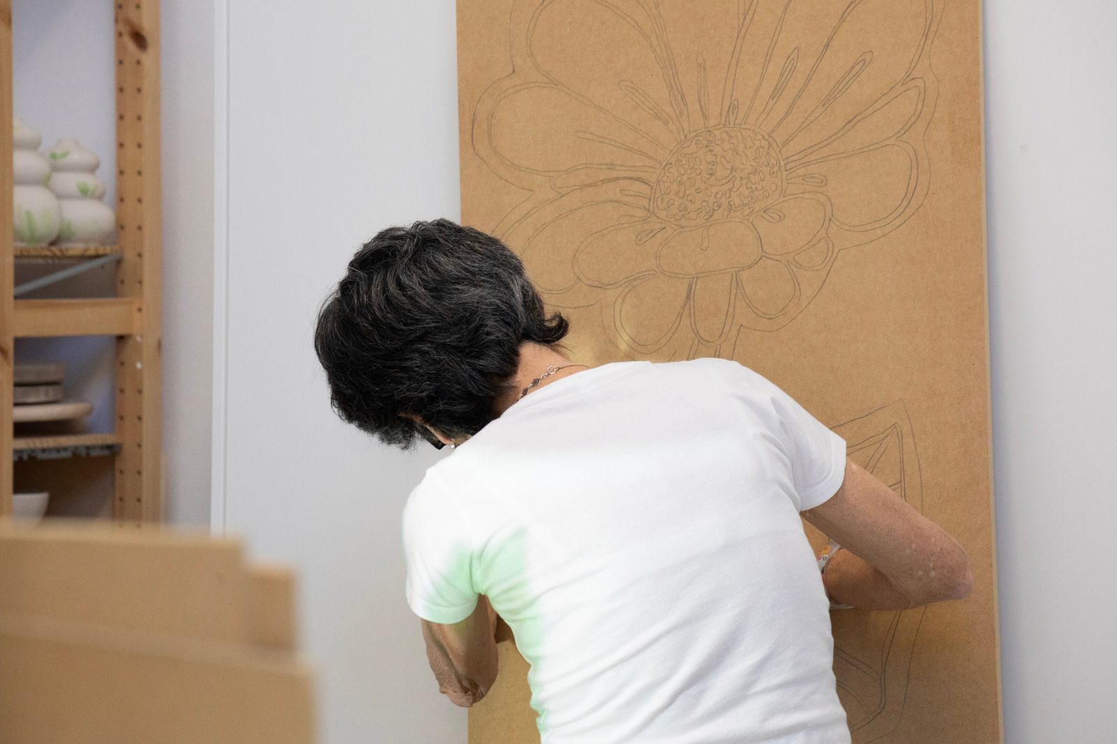 Disegno a matita di un fiore tracciato su un pannello in legno