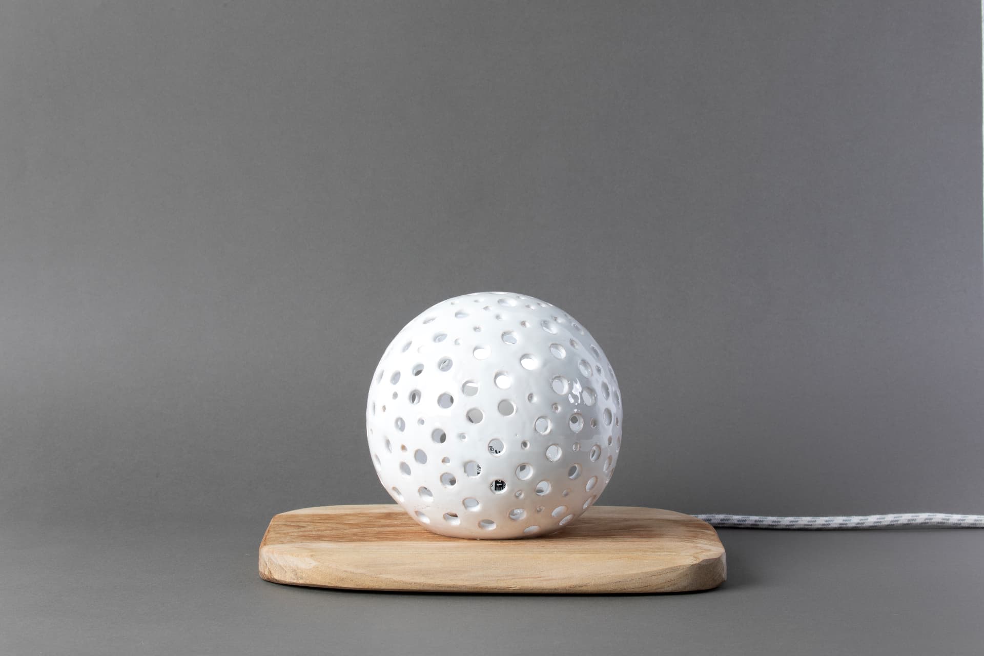 Costellazione, lampada sfera traforata in ceramica bianca, su base in legno